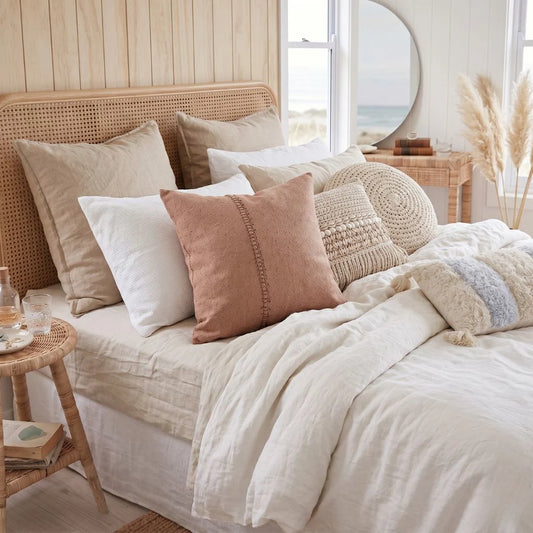 Neatly made bed with decorative pillows in a bedroom setting