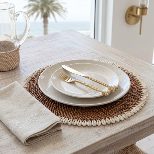 Dining table setting with plates, cutlery, and a woven placemat on a wooden table.