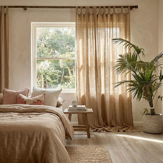 Cozy bedroom with natural organic linen curtains and beige bedding
