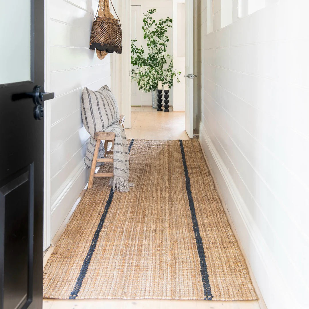 Woven mat with striped pattern on a wooden floor in a home setting