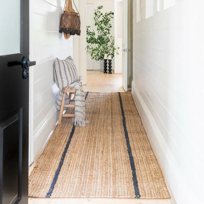 Woven mat with striped pattern on a wooden floor in a home setting