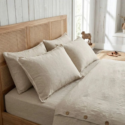 Beige bedding set on a bed with a wooden headboard in a bright room.