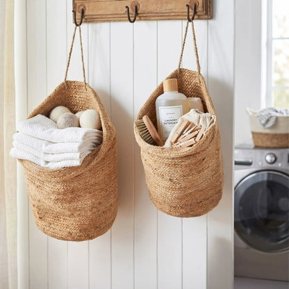 Two woven baskets hanging on a wall with laundry items inside, next to a washing machine.
