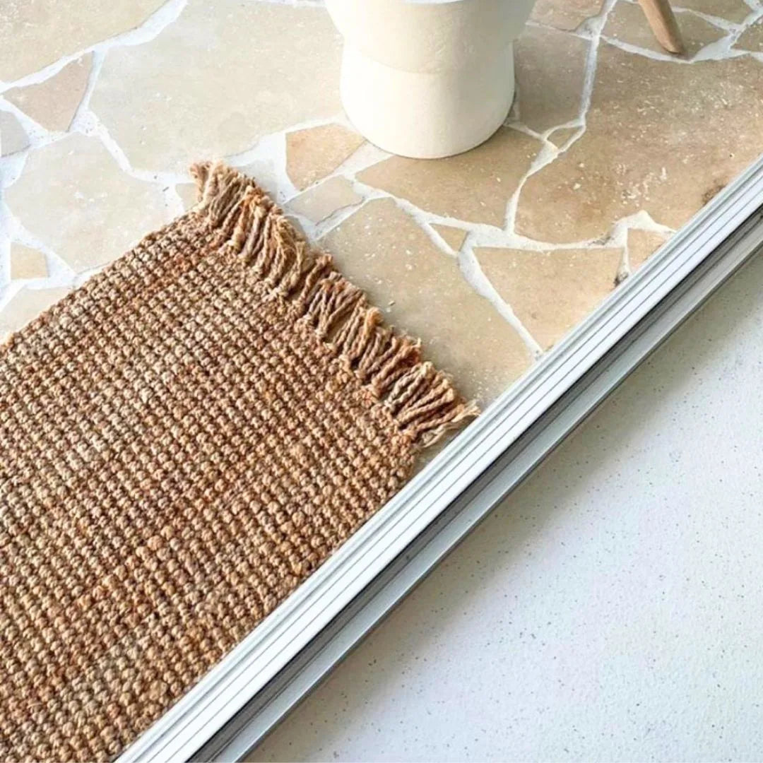 jute woven mat on a stone-patterned floor with a white cup.
