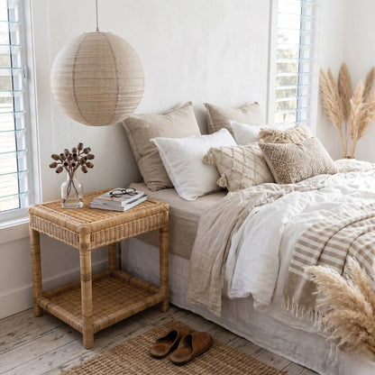 Cozy bedroom with a bed, wicker nightstand, and decorative elements.