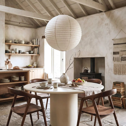 Dining room with wooden chairs, round table, and shelves with decor items.