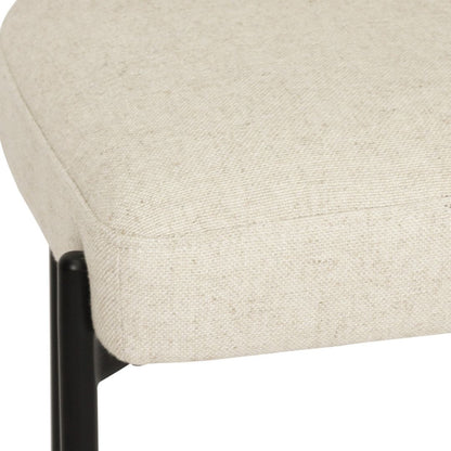 Close-up of a beige upholstered chair with a black metal frame on a white background