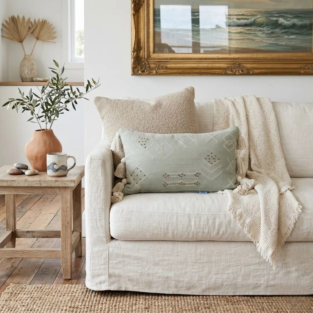 Styled living room with light coloured sofa featuring boho folk cushion