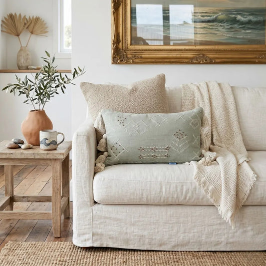 Styled living room with light coloured sofa featuring boho folk cushion