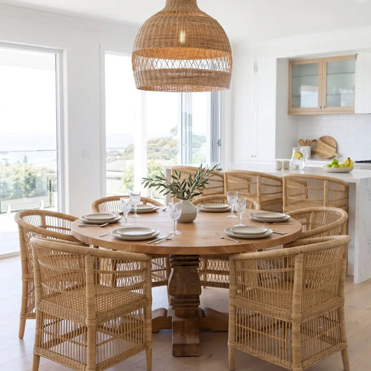 Dining area with wooden table and wicker chairs in a bright room.