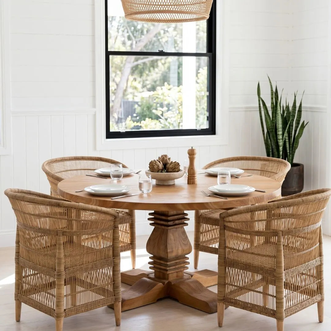Dining room with wooden table and wicker chairs near a window.