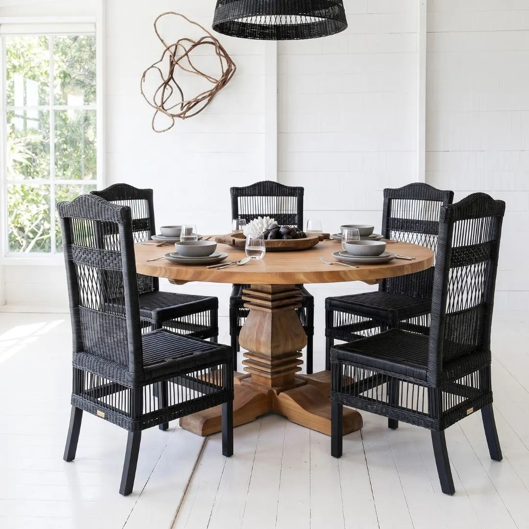 Dining room with wooden table and black chairs on a white floor.