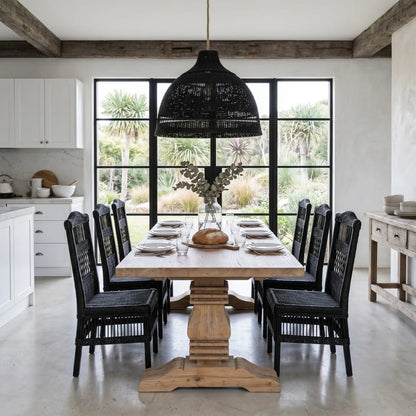 Dining room with wooden table and black chairs, large windows, and outdoor view.