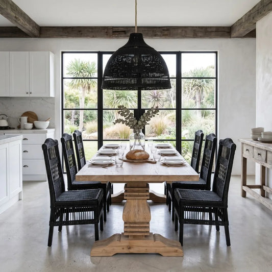 Dining room with wooden table and black chairs, large windows, and outdoor view.