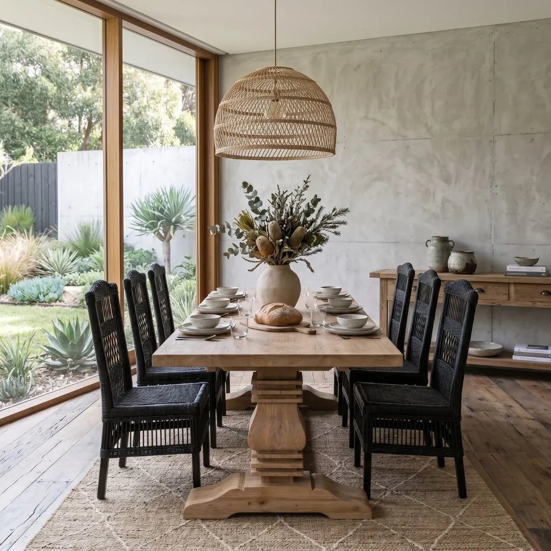 Dining area with wooden table, black chairs, and decorative elements in a modern home setting.