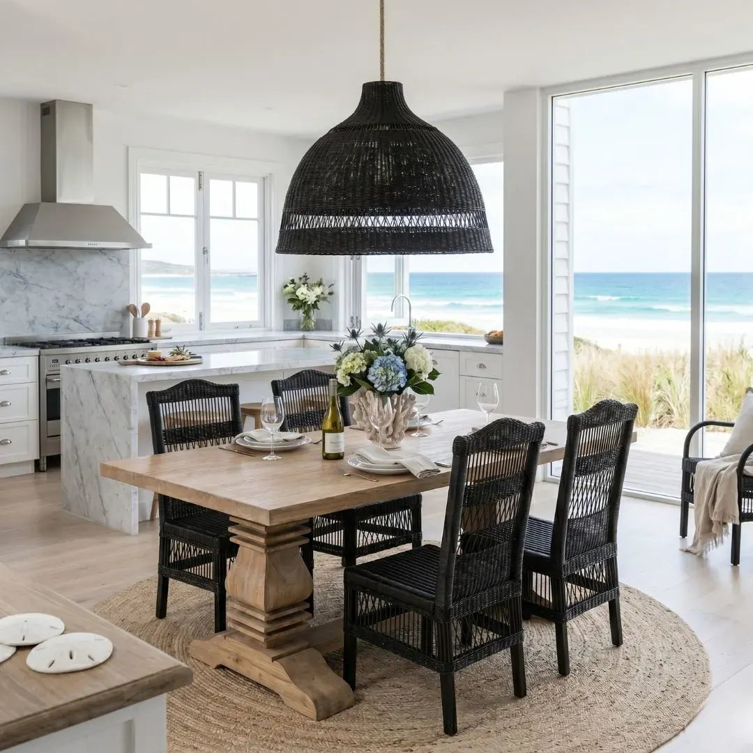 Dining area with wooden table and black chairs in a kitchen with ocean view