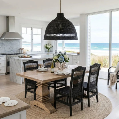 Dining area with wooden table and black chairs in a kitchen with ocean view