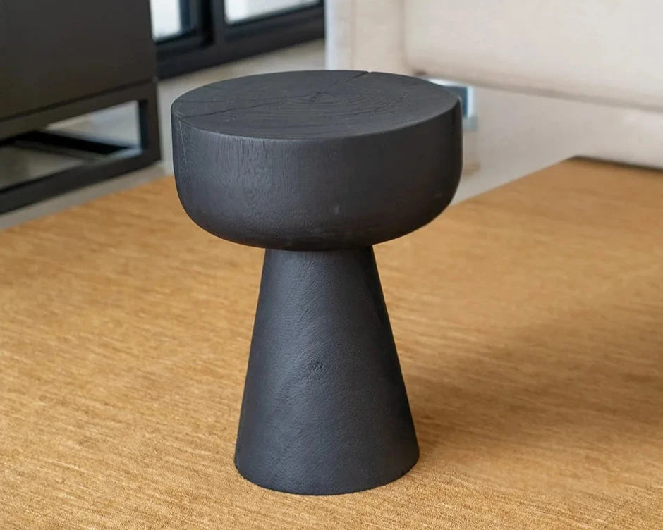 Black stool on a wooden floor with a blurred background