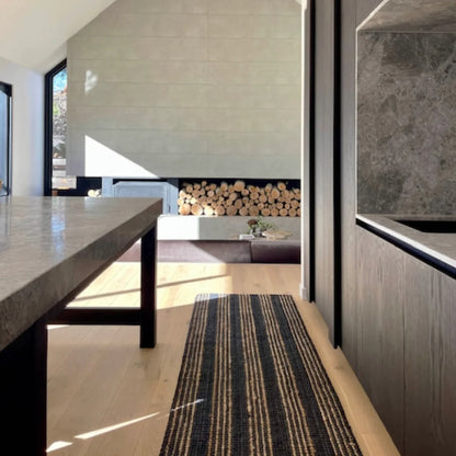 Modern interior with a dining table, rug, and fireplace.