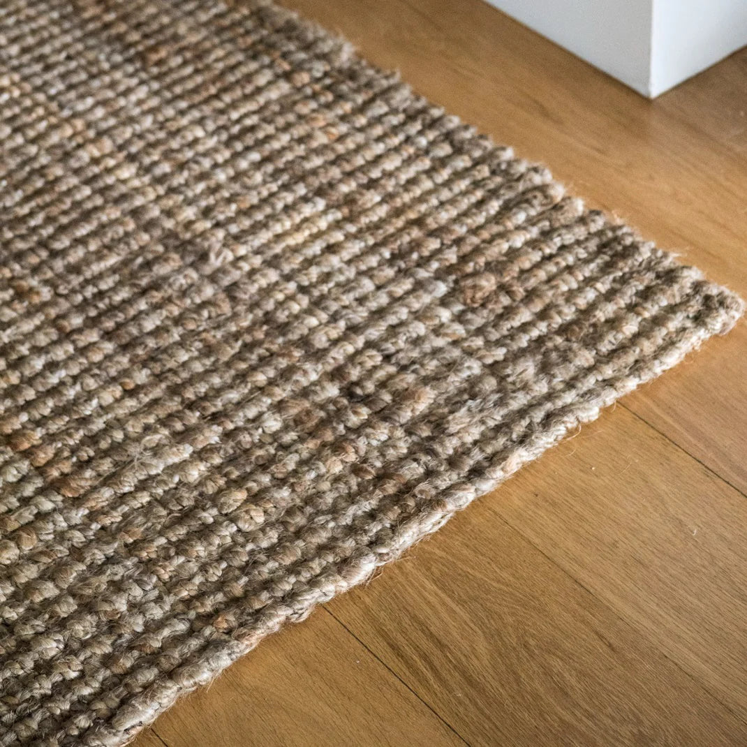 Textured natural jute rug on a wooden floor