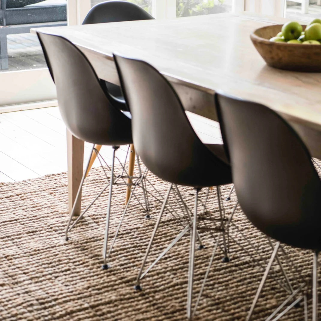 Dining table with black chairs on a textured rug