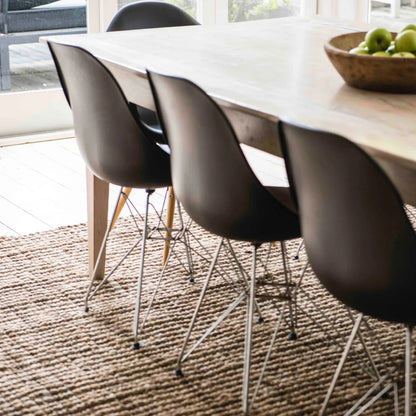 Dining table with black chairs on a textured rug