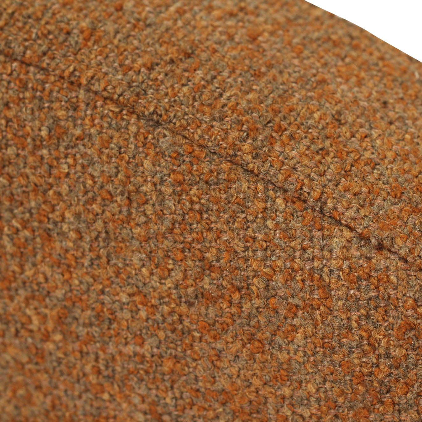 Close-up of a textured tweed fabric in a warm brown and orange colorway, showing the woven pattern and a diagonal seam against a white background.