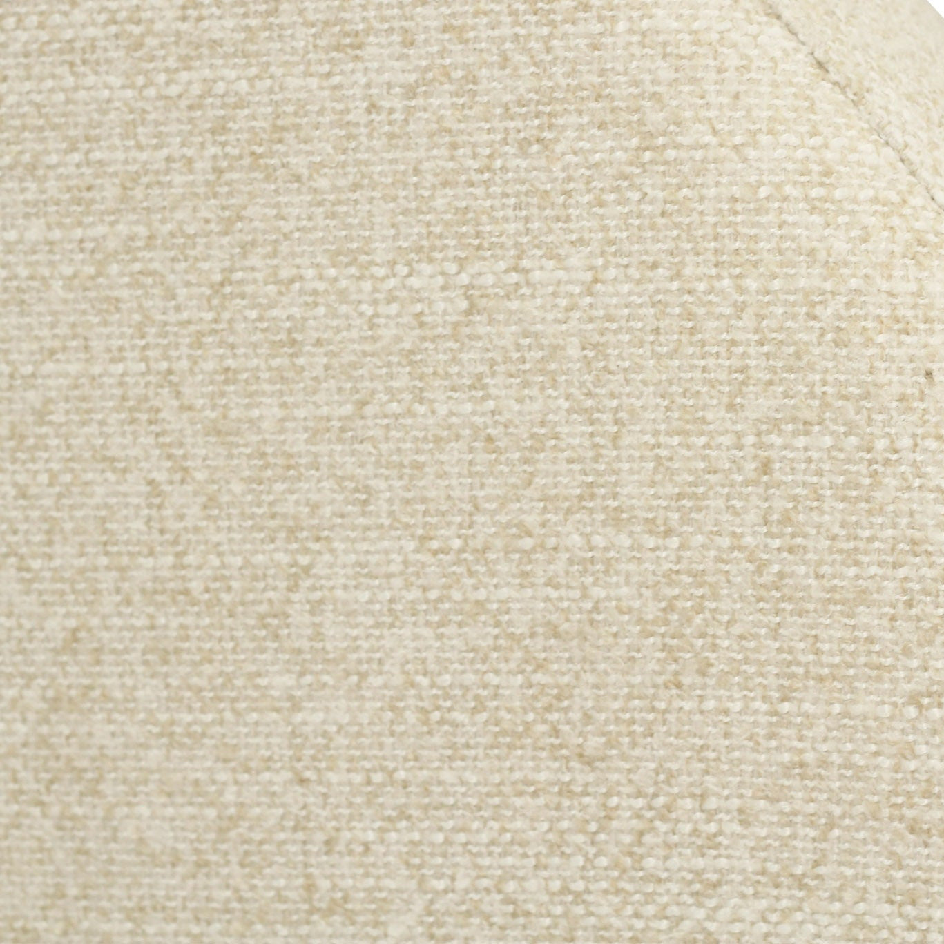 Close-up of a textured woven fabric in a warm cream or light beige color, showing the material grain and a curved seam against a white background.