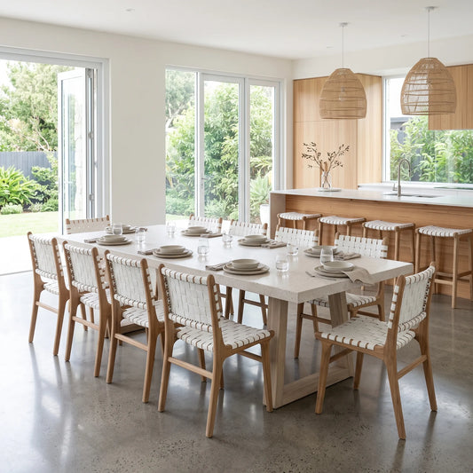Modern kitchen and dining room featuring Sun Republic Otis woven leather and teak dining chairs and stools, rattan pendants and terrazzo stone dining table