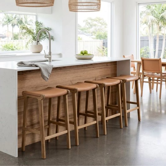 Sun Republic Natural Tan Leather and Teak stools in front of a kitchen counter in a modern open plan kitchen and dining room