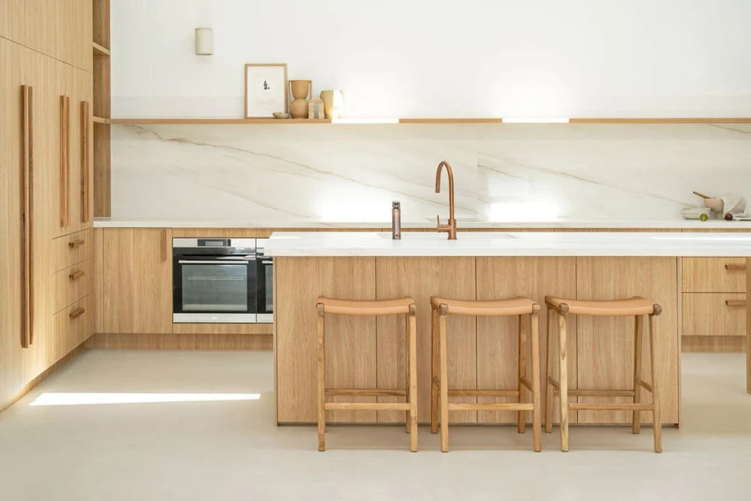 Modern kitchen with wooden cabinets, island, and stools.