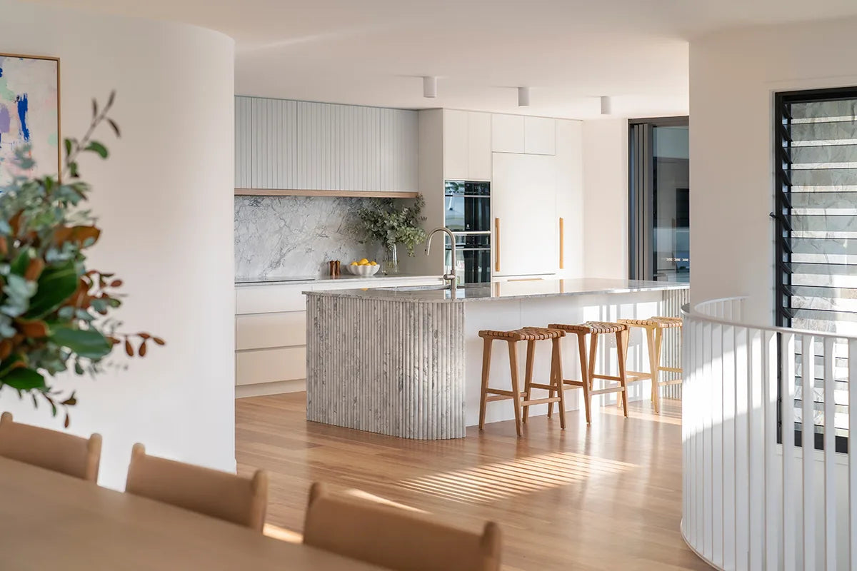 Modern kitchen with marble island and wooden chairs