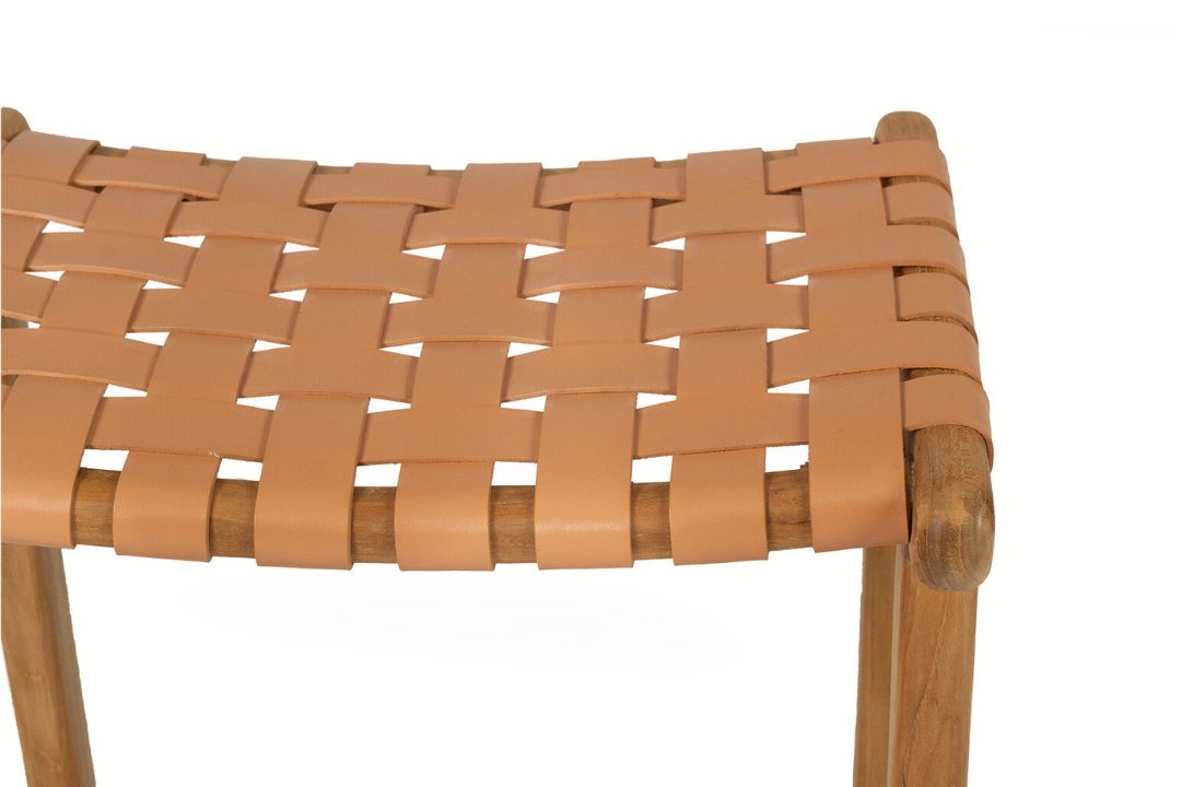 Close-up of a woven leather stool with wooden legs on a white background