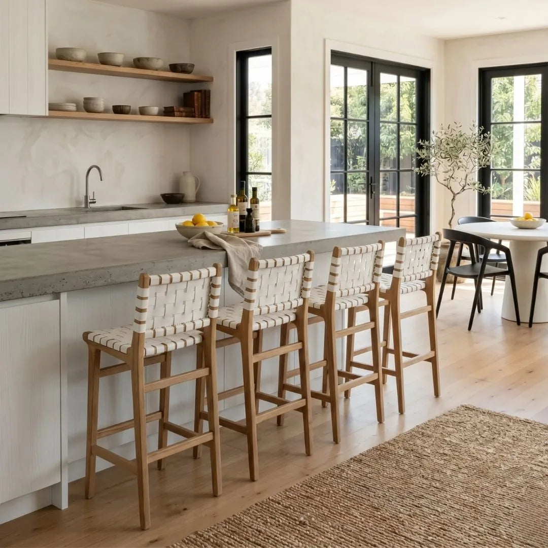 Modern kitchen with island and bar stools, large windows, and a dining area.