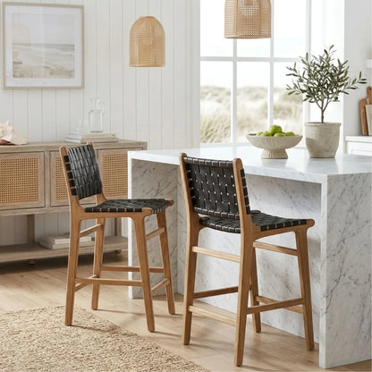 Black woven leather and teak kitchen counter stools in a modern home at a kitchen island bench