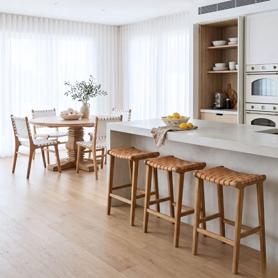 Sun Republic natural tan and teak woven leather counter stools in a modern kitchen.