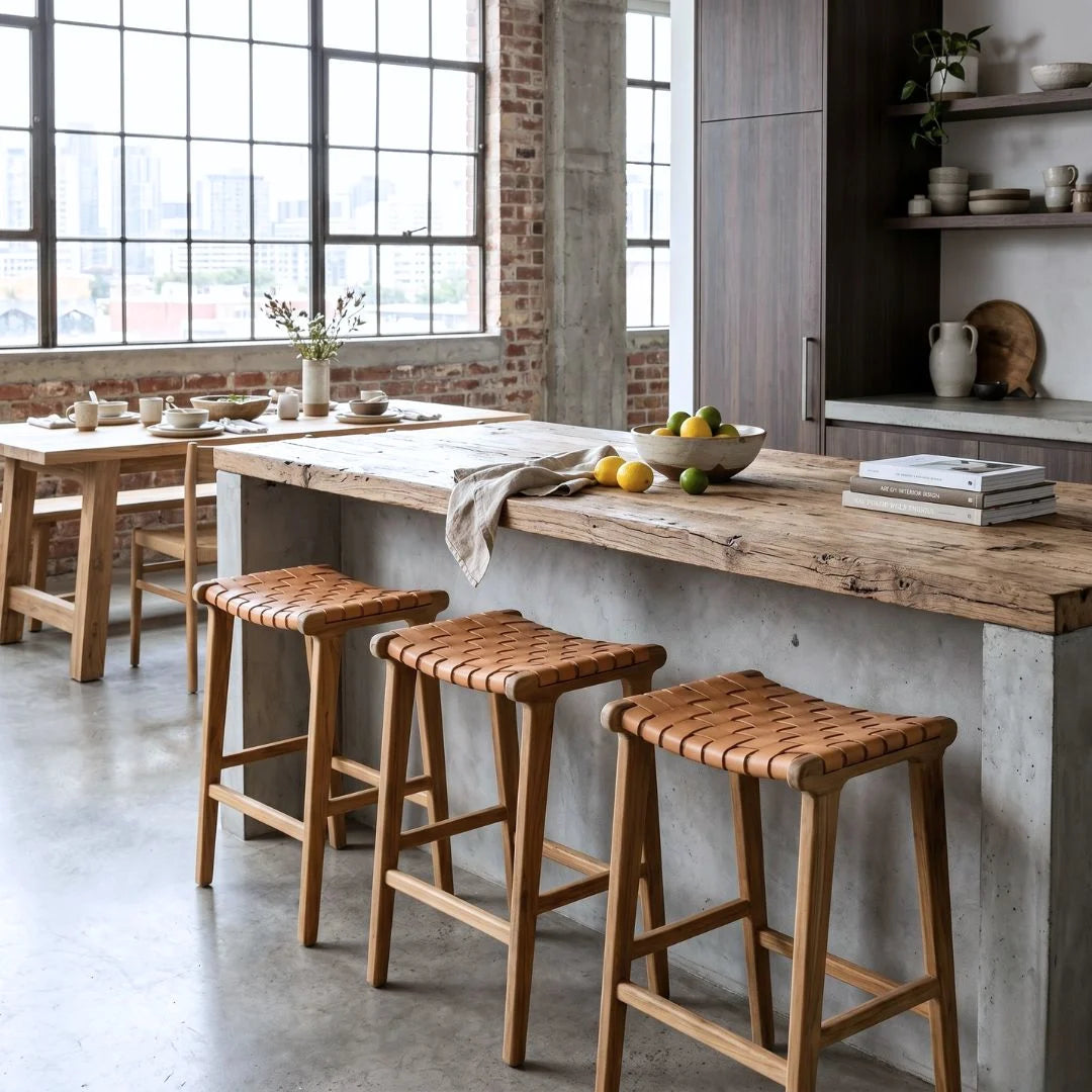 Sun Republic natural tan and teak woven leather counter stools in a industrial style apartment kitchen.
