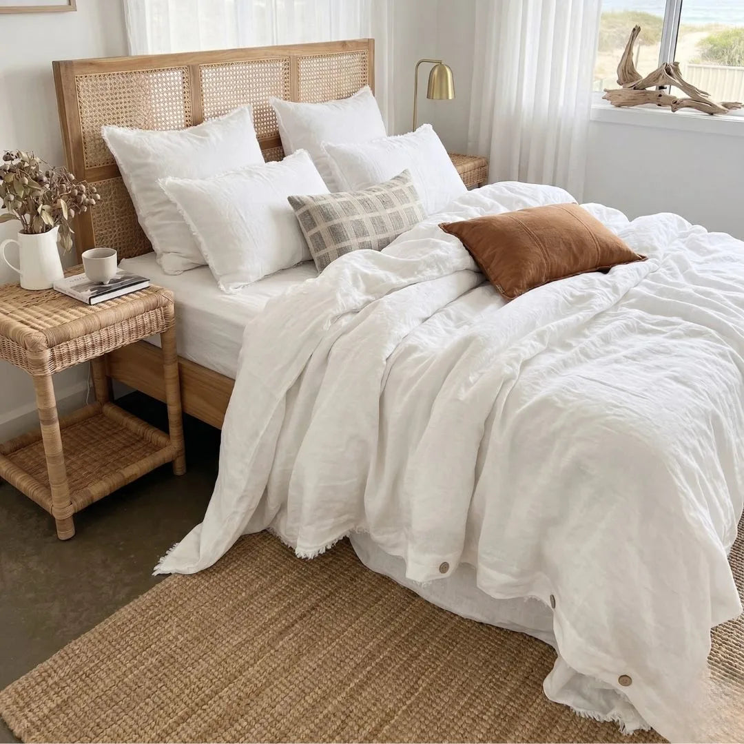 Bedroom with a wooden bed frame, white bedding, and decorative pillows.