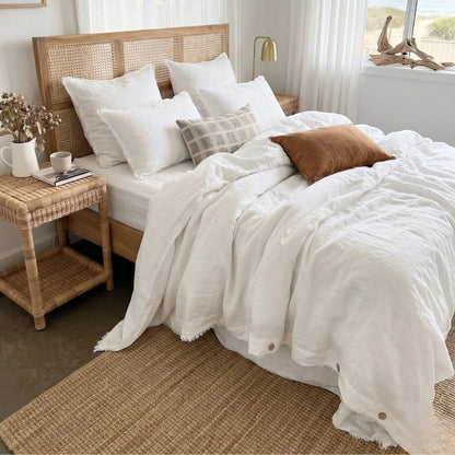 Bedroom with a wooden bed frame, white bedding, and decorative pillows.