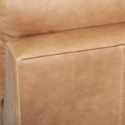 Close-up of a brown leather sofa with visible stitching
