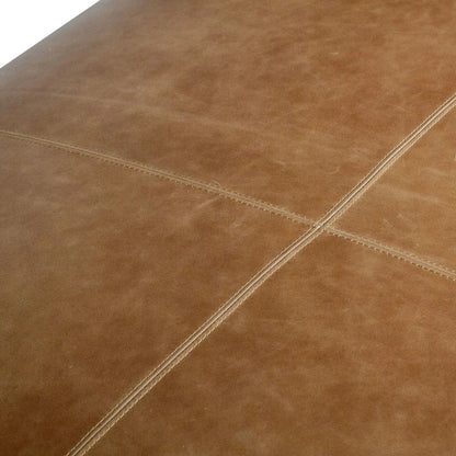 Close-up of brown leather surface with visible stitching