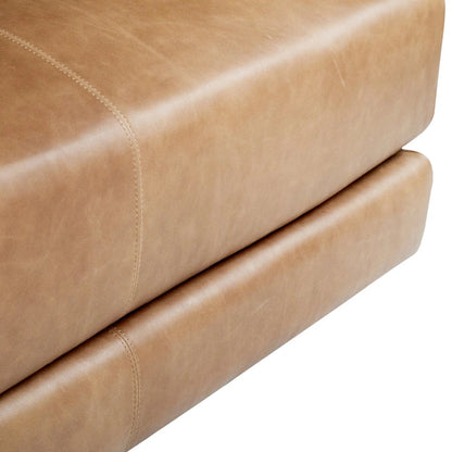 Close-up of a tan leather ottoman with visible stitching on a white background