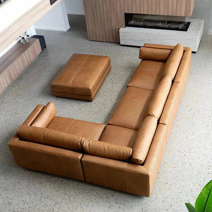 Brown leather sofa set in a modern living room with a fireplace.