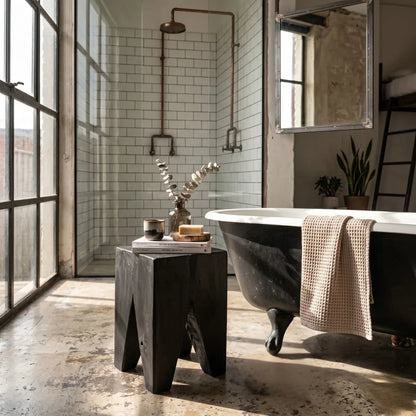Black Teak square peg stump stool in a industrial bathroom