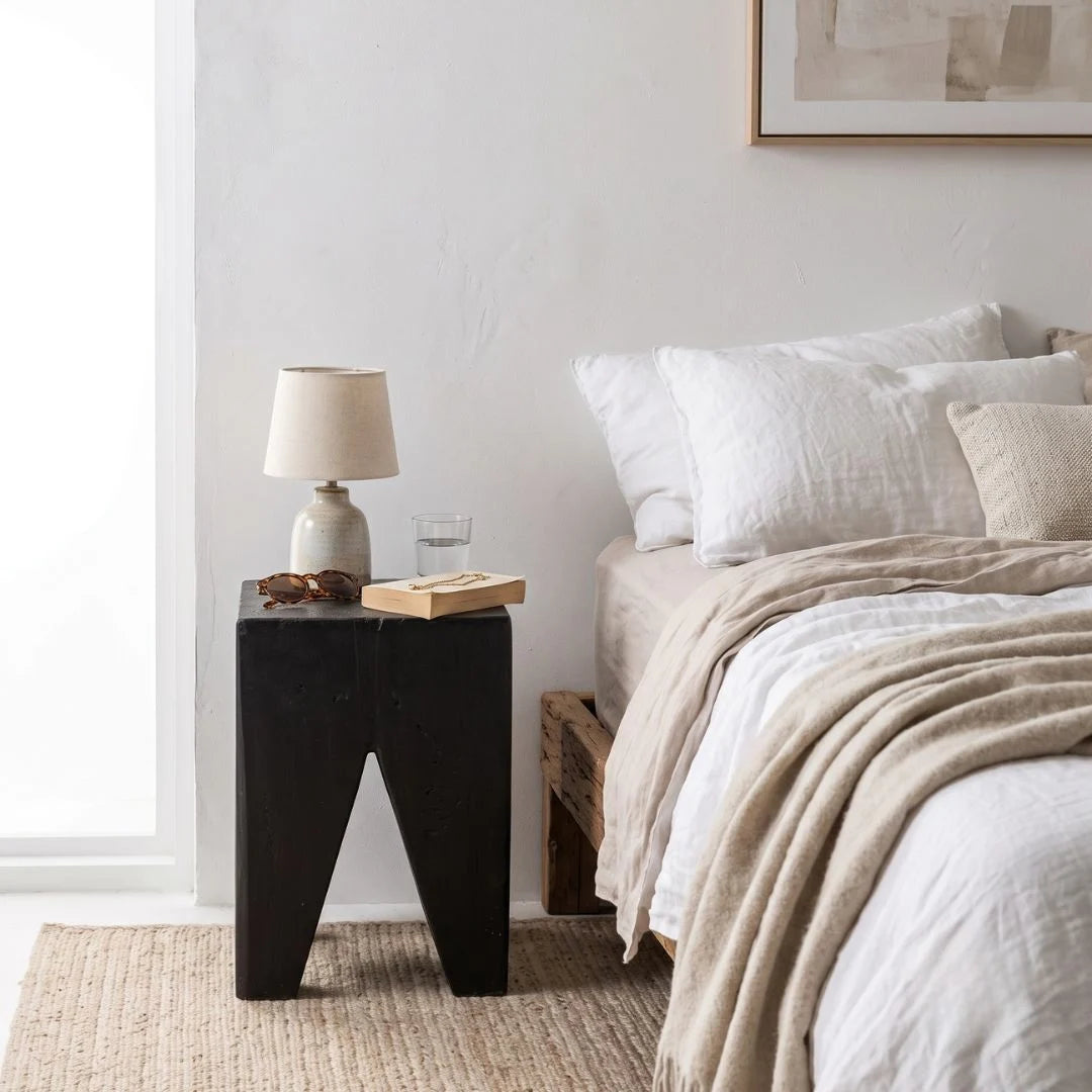 Solid Teak stump Black side table styled in a modern home. 