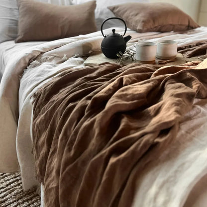 Tea set on a bed with brown and beige bedding