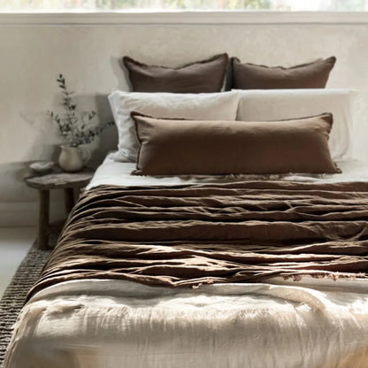 Bed with brown and beige bedding in a bedroom setting