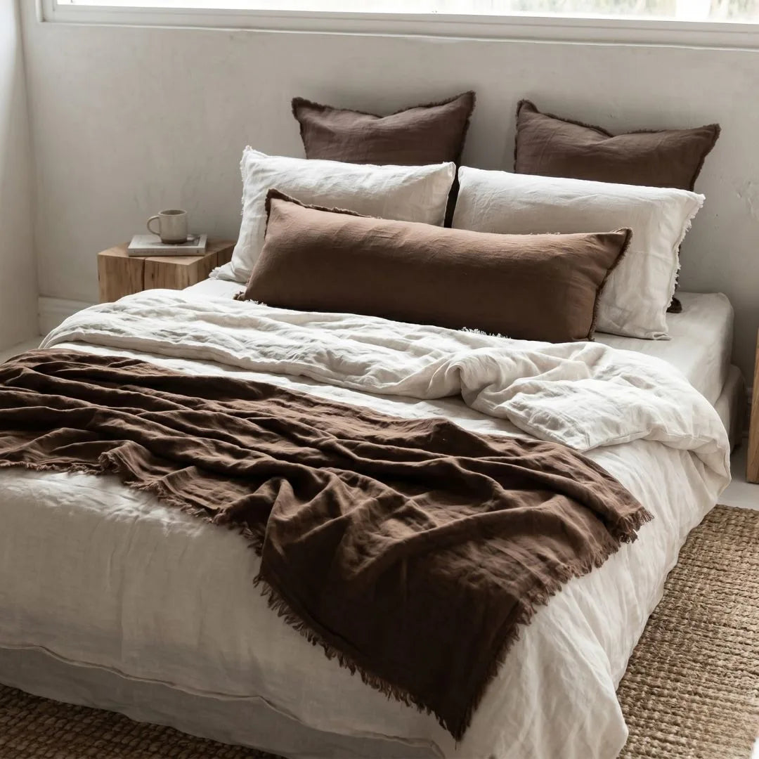 Bed with brown and white bedding in a bedroom setting