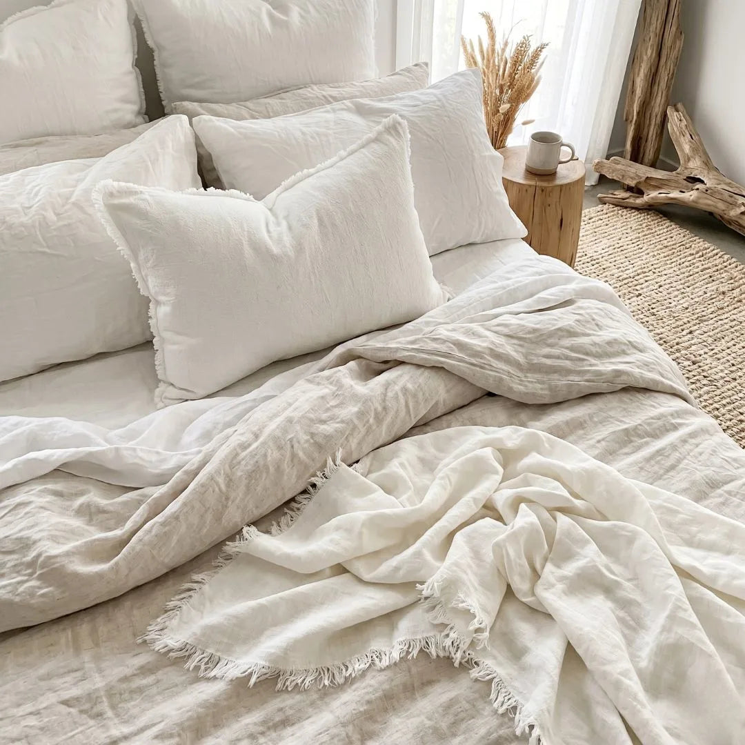 chalk white ramie linen lumbar cushion cover and matching throw blanket on a bed in a coastal style bedroom