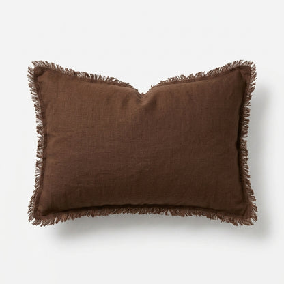A rectangular brown linen throw pillow with fringed edges, shown against a clean white background.